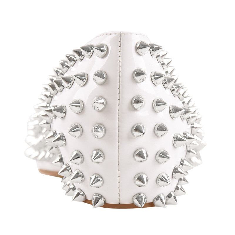 Close-up of a white heel with symmetrical silver spikes.