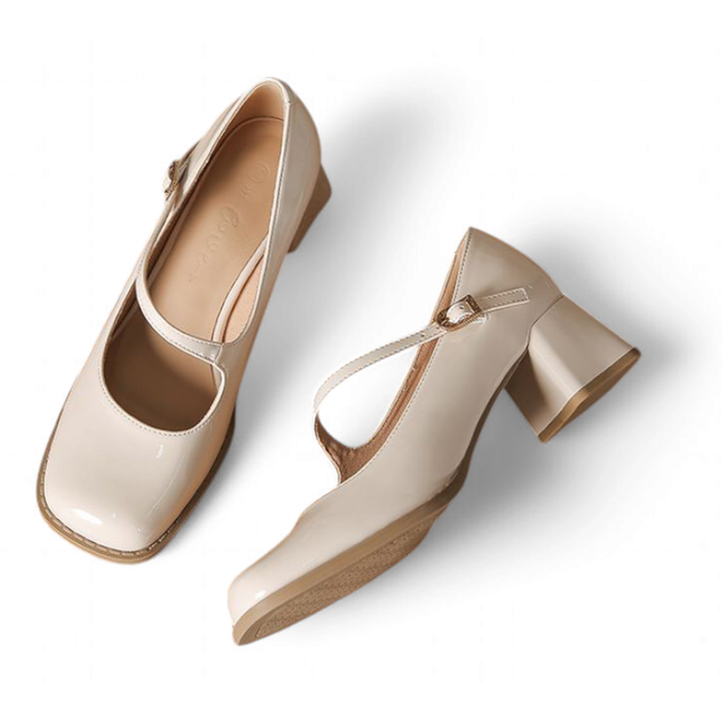 Pair of glossy beige Mary-Jane pumps laid flat on white background, angled top view.