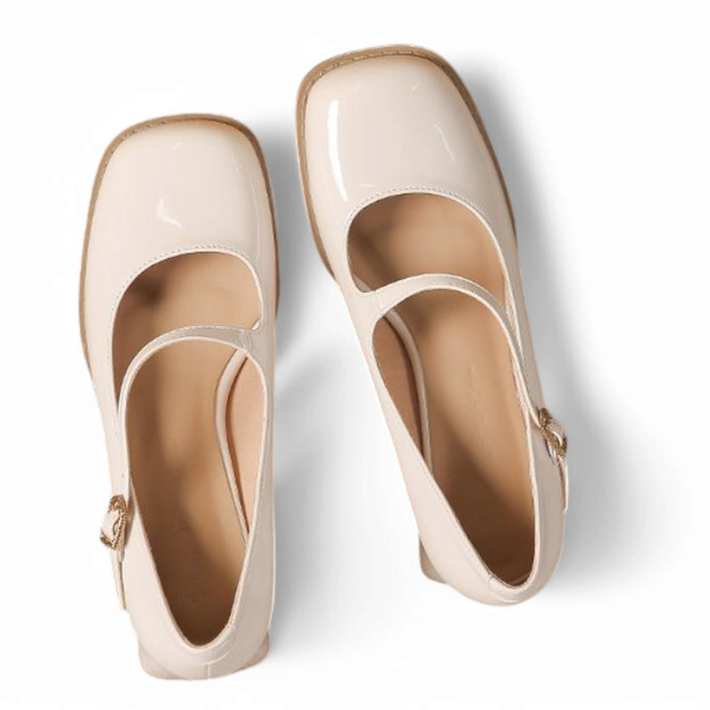 Top view of glossy beige Mary-Jane pumps highlighting square toe and slim strap.
