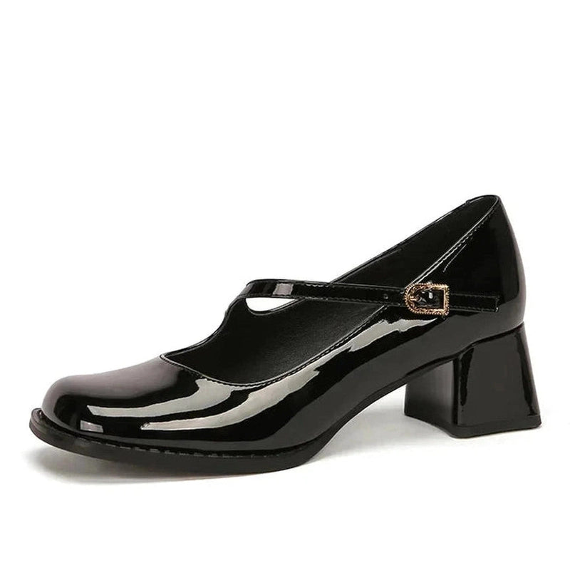 Glossy black Mary-Jane pump with mid block heel, side view on white background.
