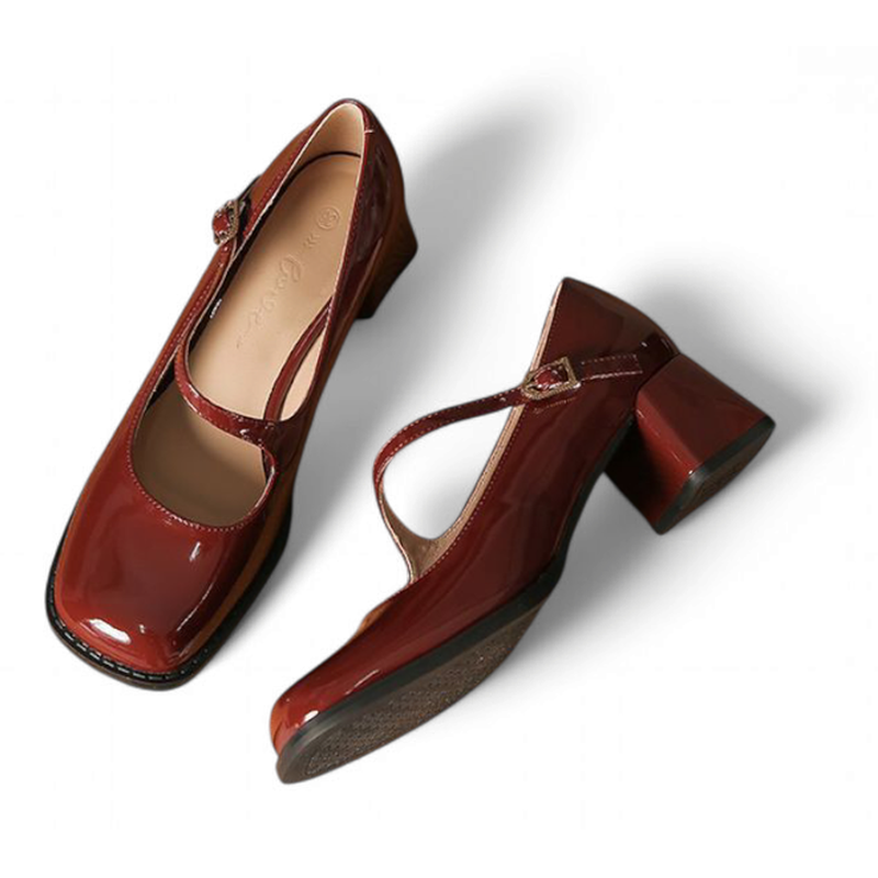 Pair of glossy burgundy Mary-Jane pumps laid flat on white background, angled top view.