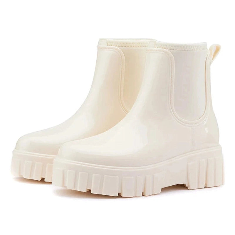 Glossy beige Chelsea boots, shown clearly from a side angle