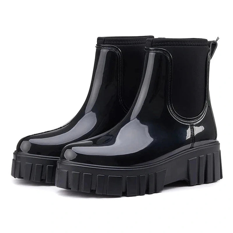 Side angle view of glossy black Chelsea boots showing full body