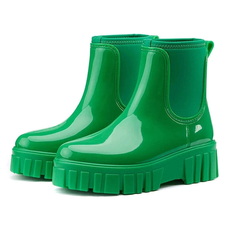 Bright green glossy Chelsea boots viewed from front-side perspective
