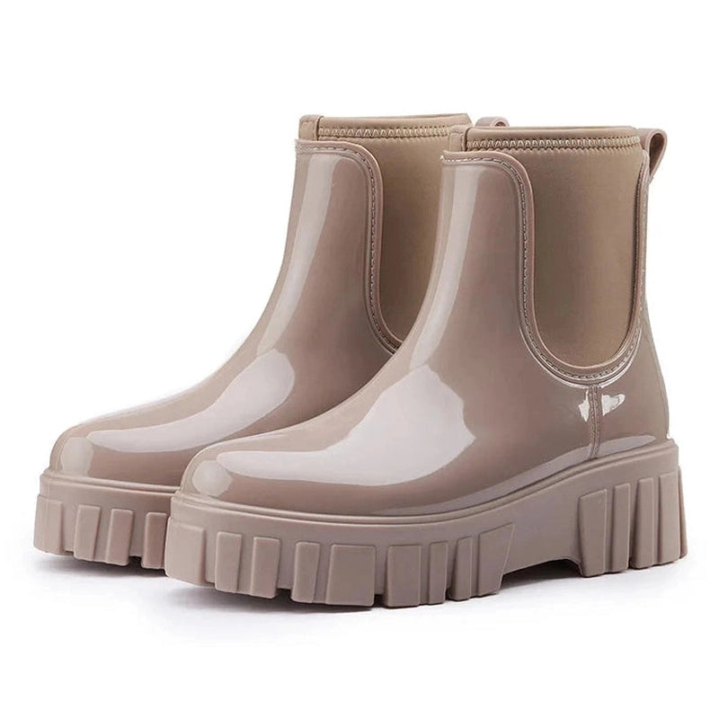 Ivory glossy Chelsea boots placed together on a white background