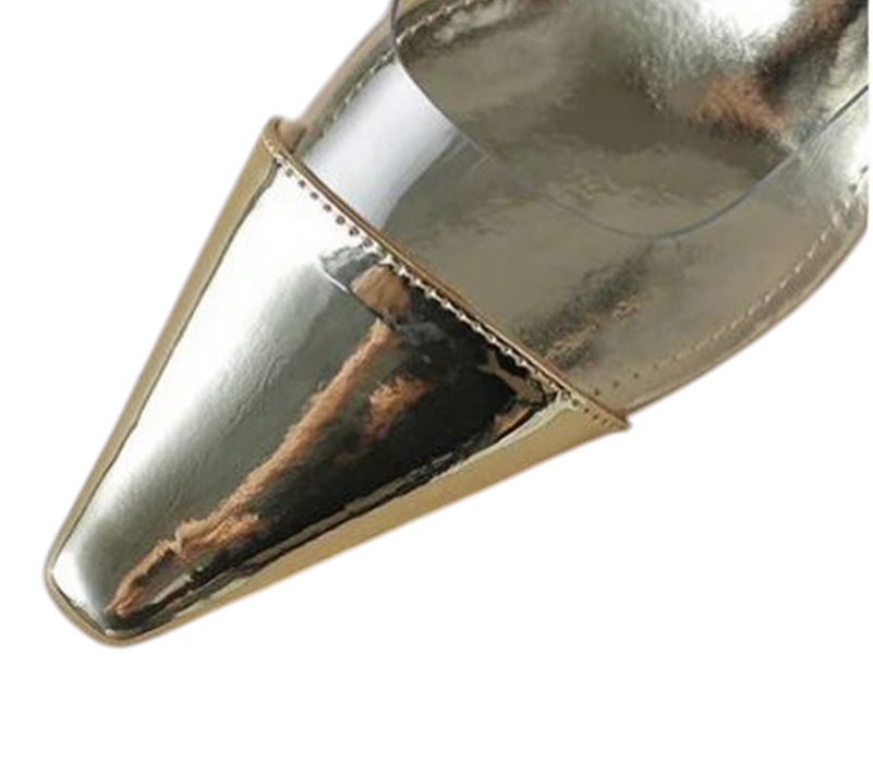 Close view of glossy gold-plated pointed toe with clear PVC panel behind it.