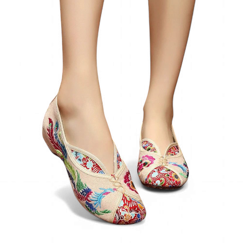 Front angle view of beige canvas flats with a V-throat vamp and multicolor embroidery, no strap.