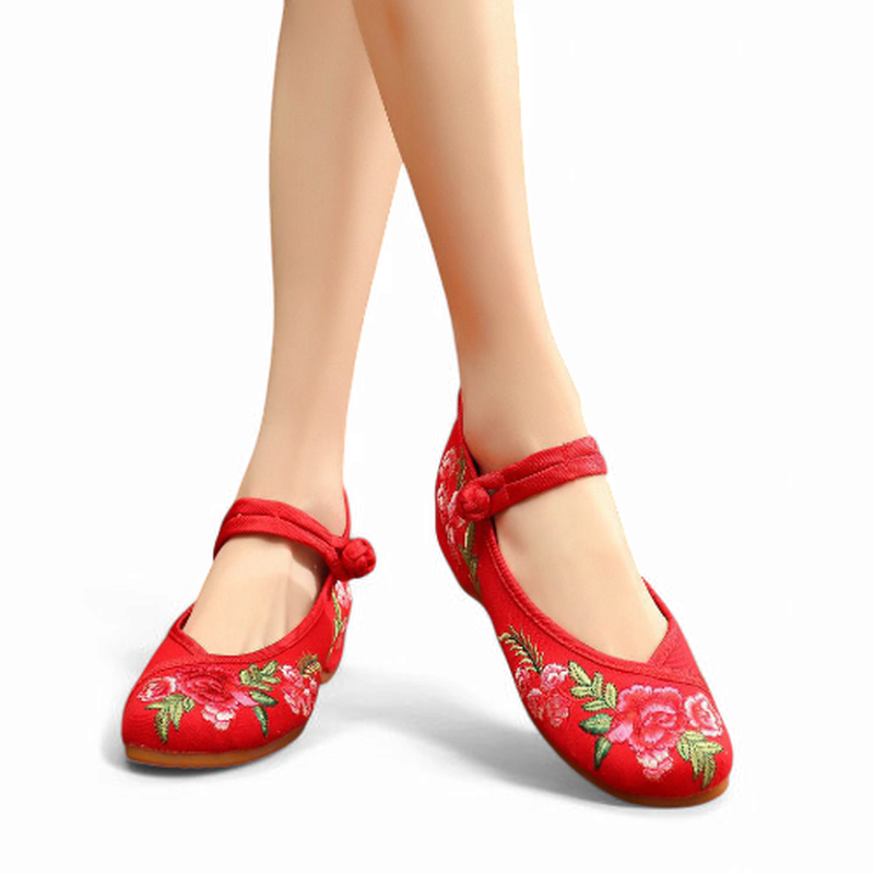 Straight front view of red embroidered Mary Jane flats with toe floral detail and a fabric knot strap.
