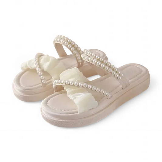 Pair of ivory open-toe platform sandals with pearl-adorned double straps on white background.