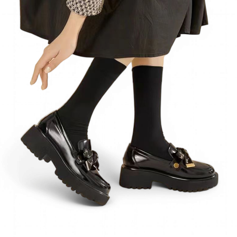 Walking image capturing the patent-like shine of the black loafer.