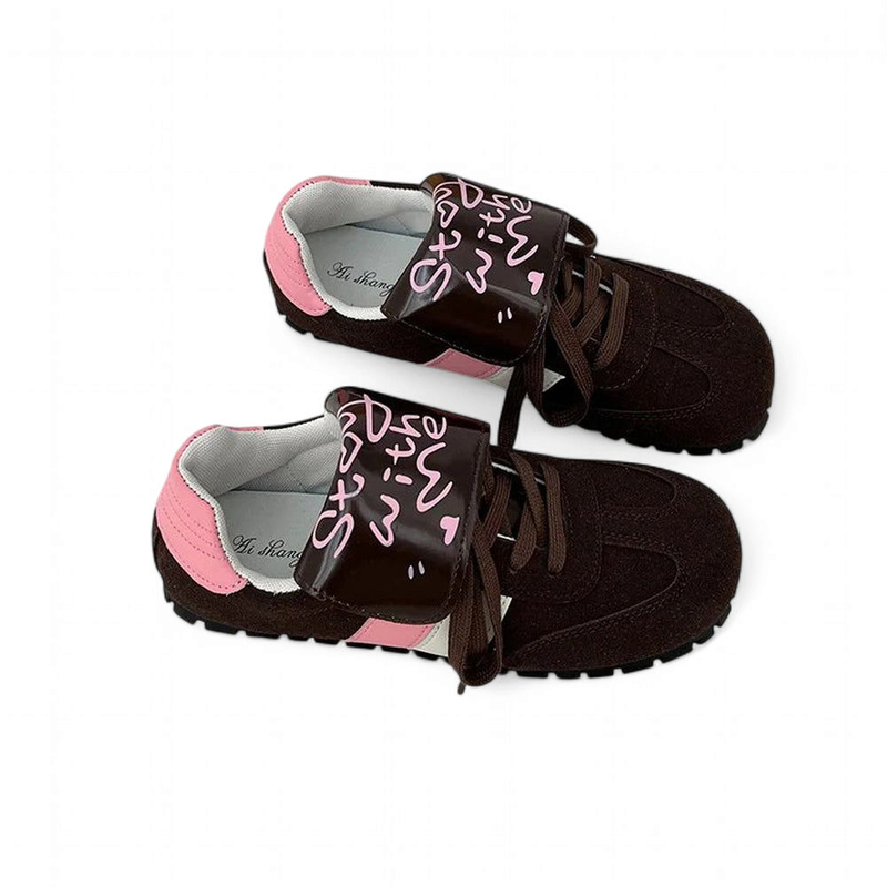 Brown sneaker with pink-printed velcro flap and ridged rubber outsole.

