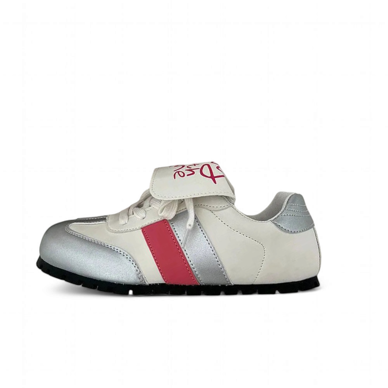 White sneaker with silver accents, pink side stripe, and top velcro strap.