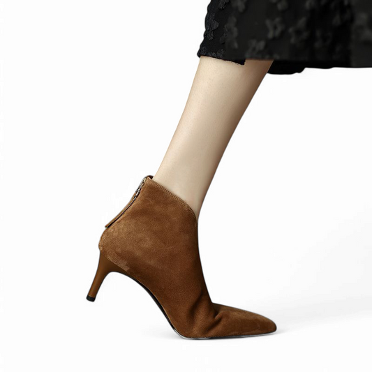 Brown suede boot with slim heel, leg in slight motion and bent knee.

