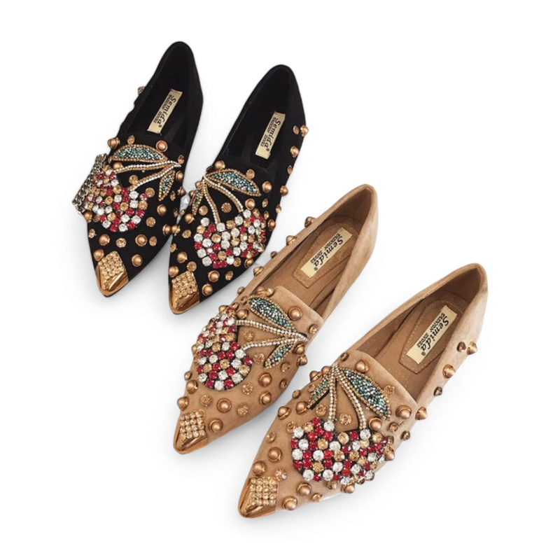 Black and camel embellished mules arranged diagonally on white background