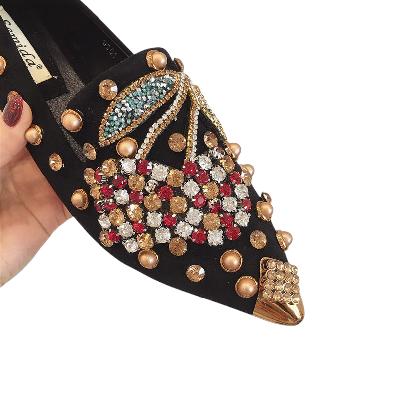 Close‑up of red, gold and turquoise crystal embellishment on black mule
