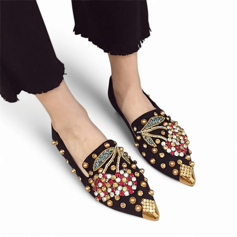 Embellished black mule worn with black trousers, front‑side view