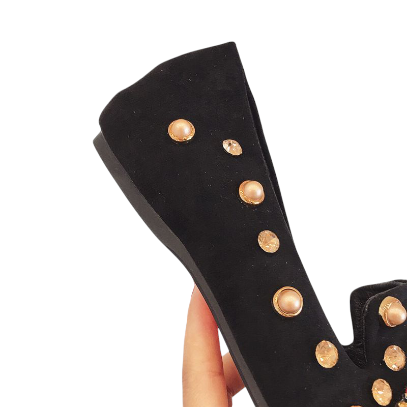 Side view showing gold studs and sole of black velvet mule