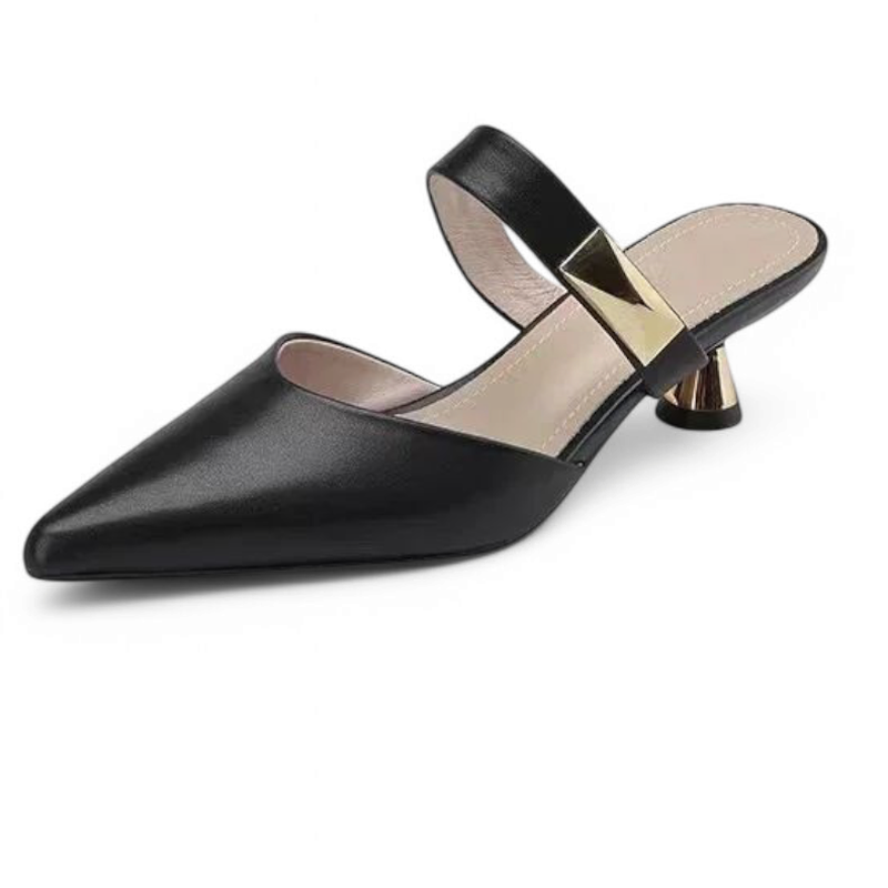 Black shoe on white background, showing pyramid buckle strap and gold heel.
