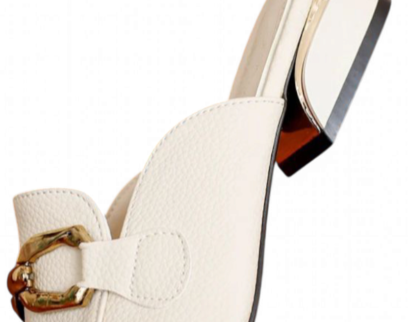 Close-up of ivory leather mule showing gold-trimmed square heel and bamboo buckle.	