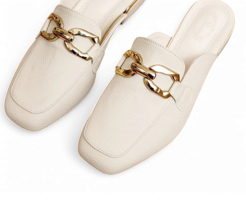 Top view of ivory round-toe mules with linked gold buckle detailing