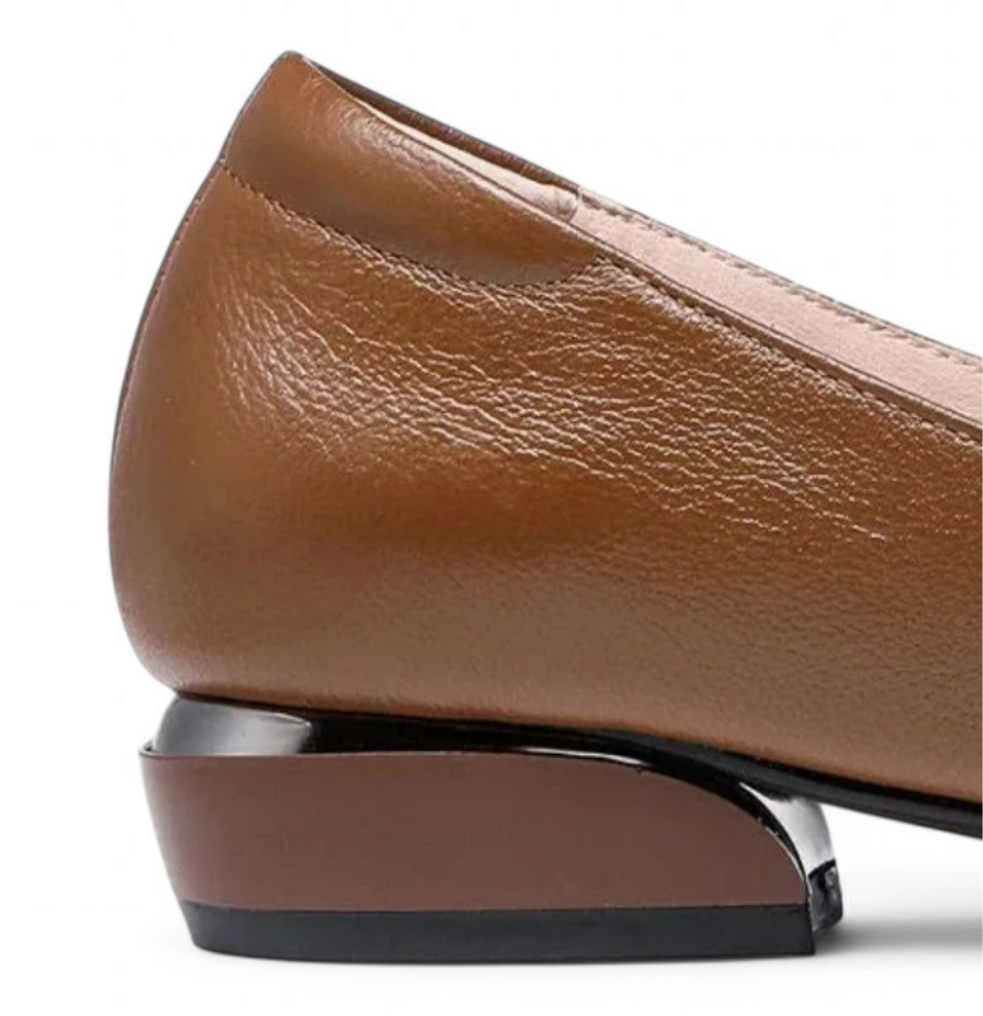 Close view of the low sculpted heel on the brown flat with a slight sheen.