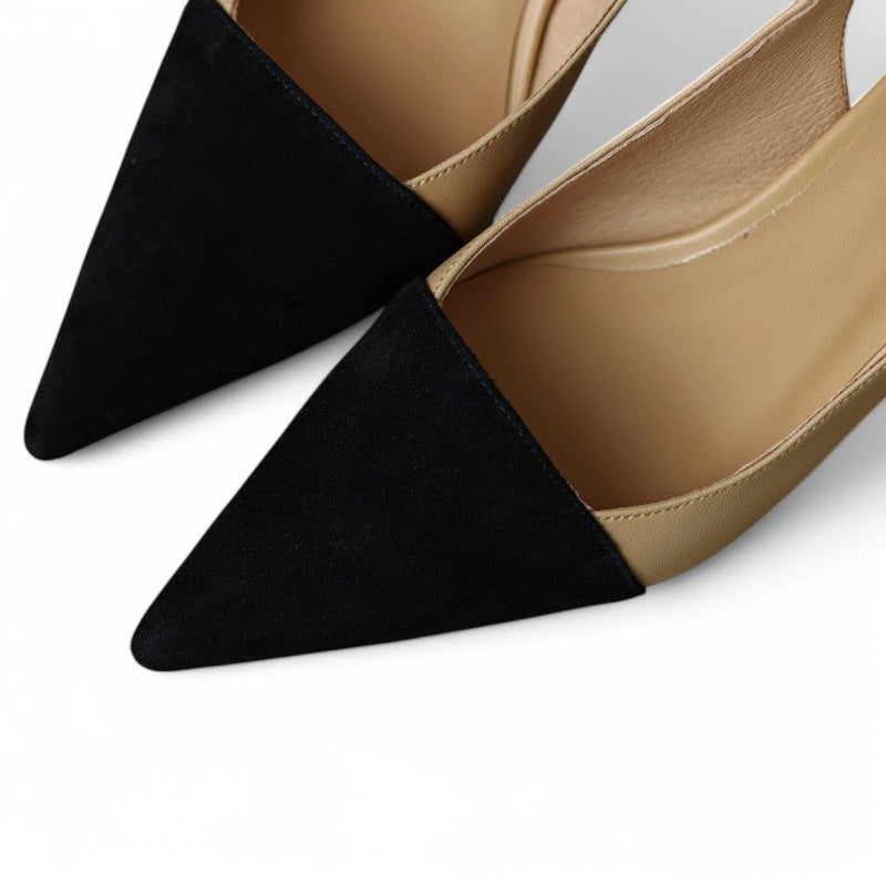 Close-up of black suede pointed toe meeting smooth khaki leather.
