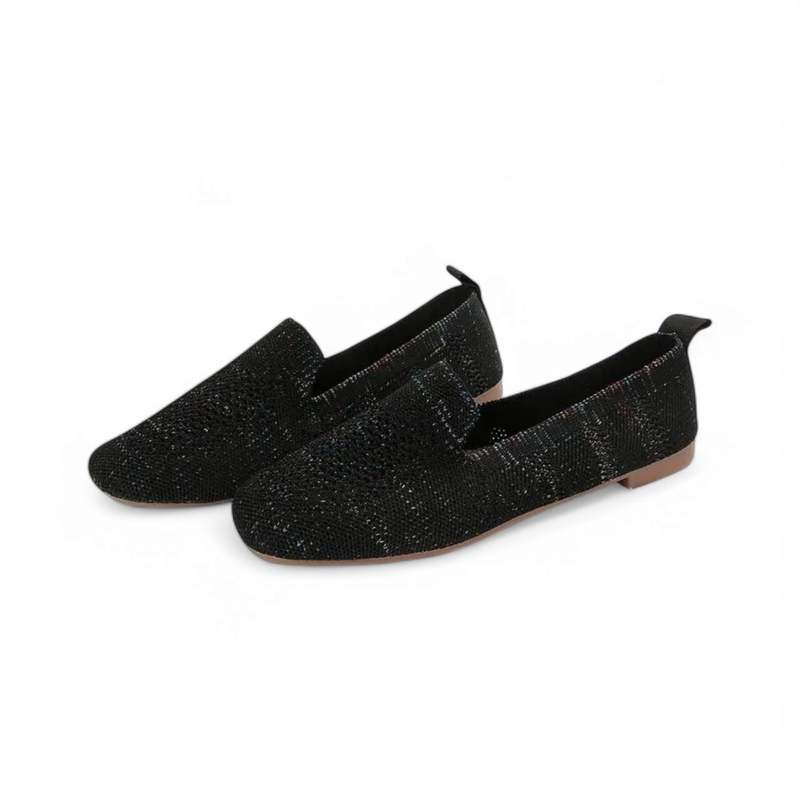 Studio three-quarter pair view of black knit slip-on loafers.