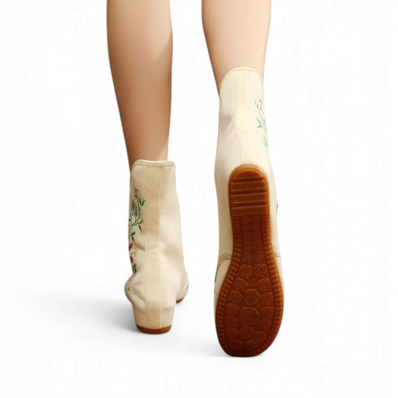 Rear shot of beige boot pair highlighting patterned rubber sole and continuous hidden wedge.
