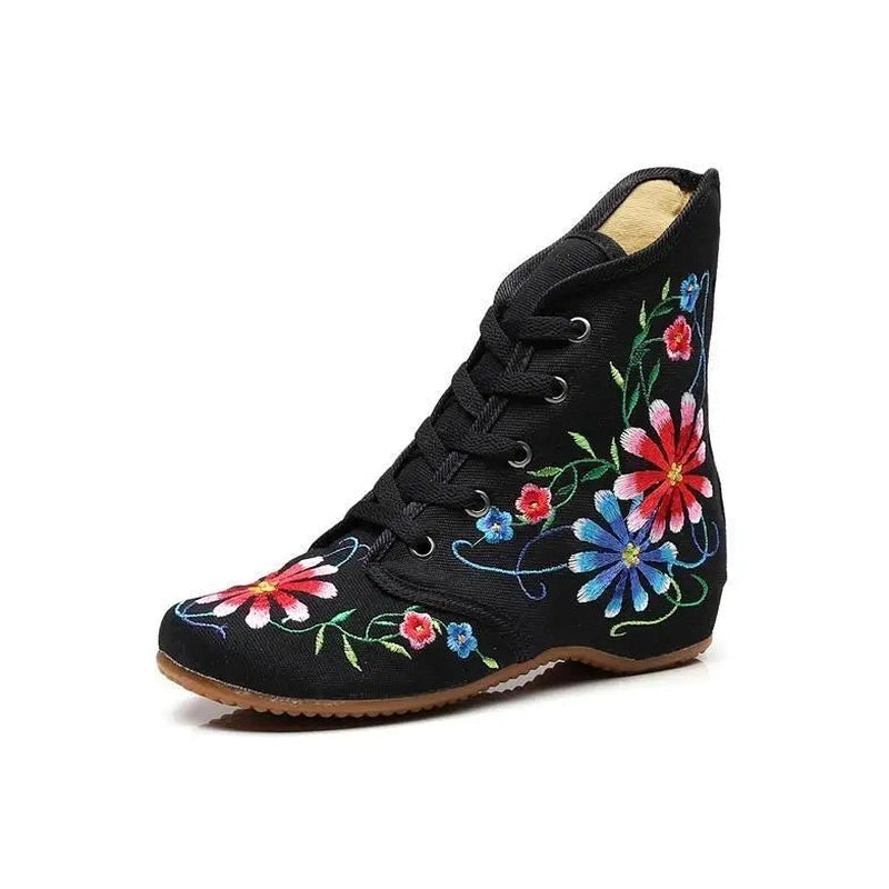 Black single boot with multi-colour floral stitching and brown rubber outsole.

