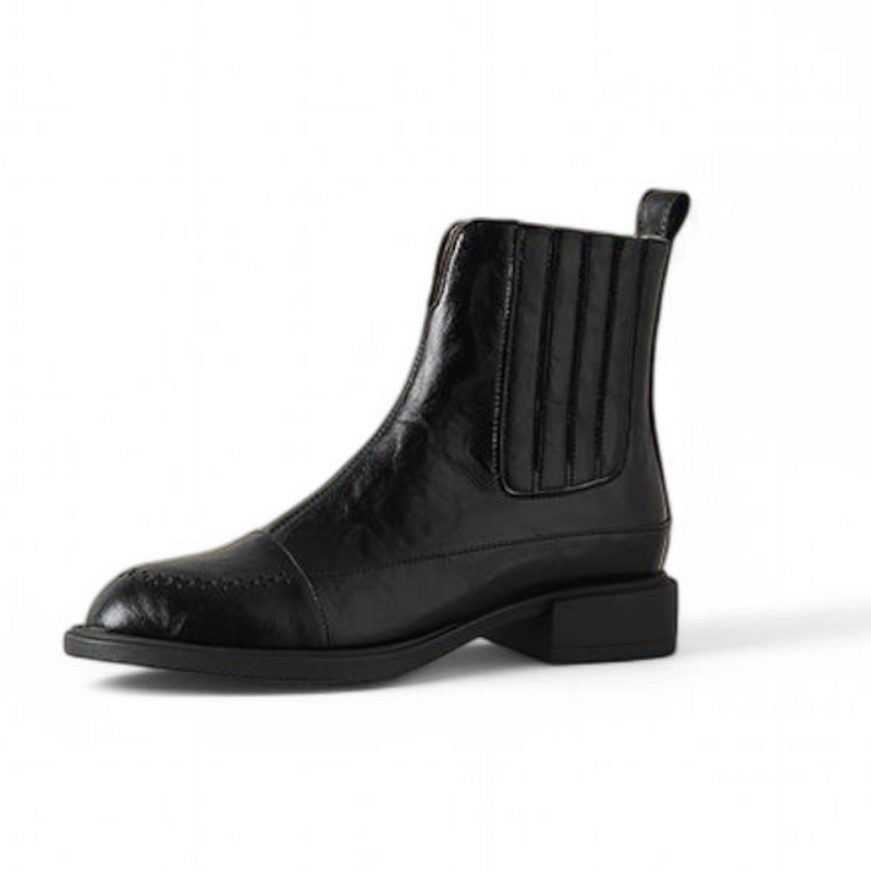 Men’s black Chelsea boot with round toe and medium heel, shown in a single side profile


