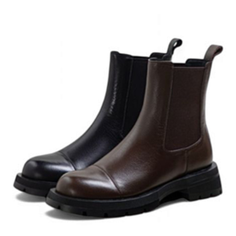 Black and brown Chelsea boots side by side on neutral background