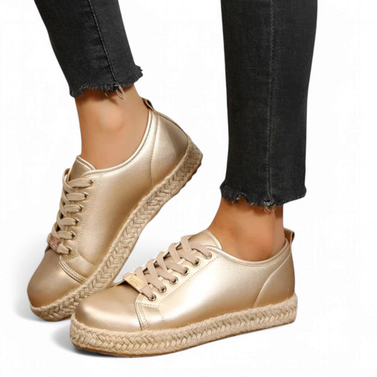 Side shot of two sneakers in motion, highlighting the continuous jute wrap and soft gold reflection.

