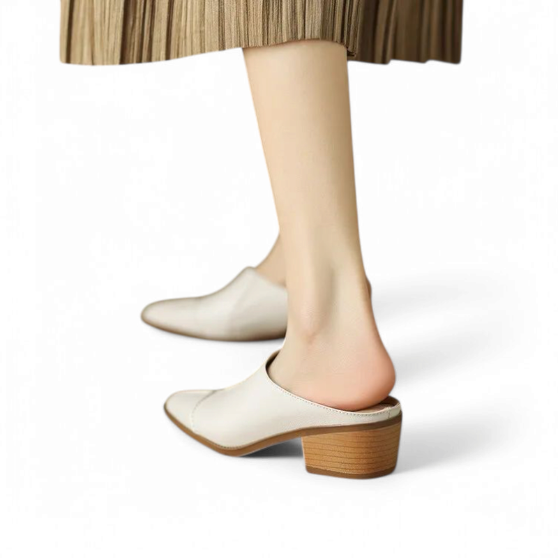 Rear angle on-foot view of ivory mule showing heel and backless design.