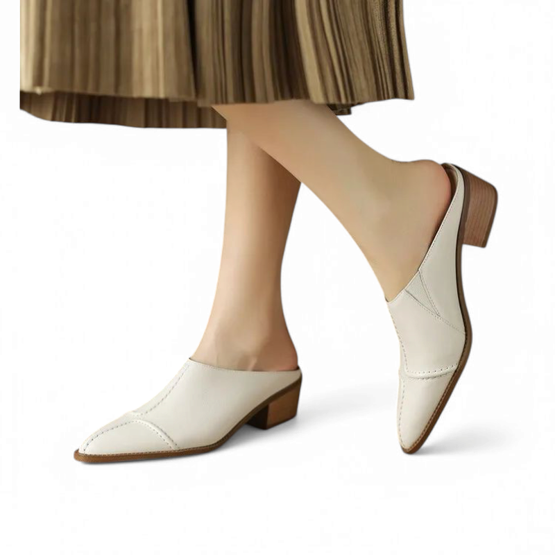 Three-quarter on-foot view of ivory mule in motion, pointed toe visible.