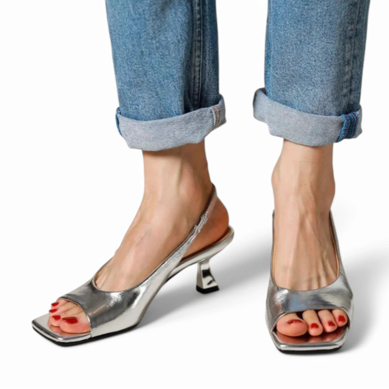 Silver slingback with sculpted heel, side-front angle in motion