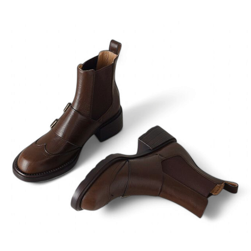 Front view of Brown leather Chelsea boots with round toe and front-facing belt buckle design.
