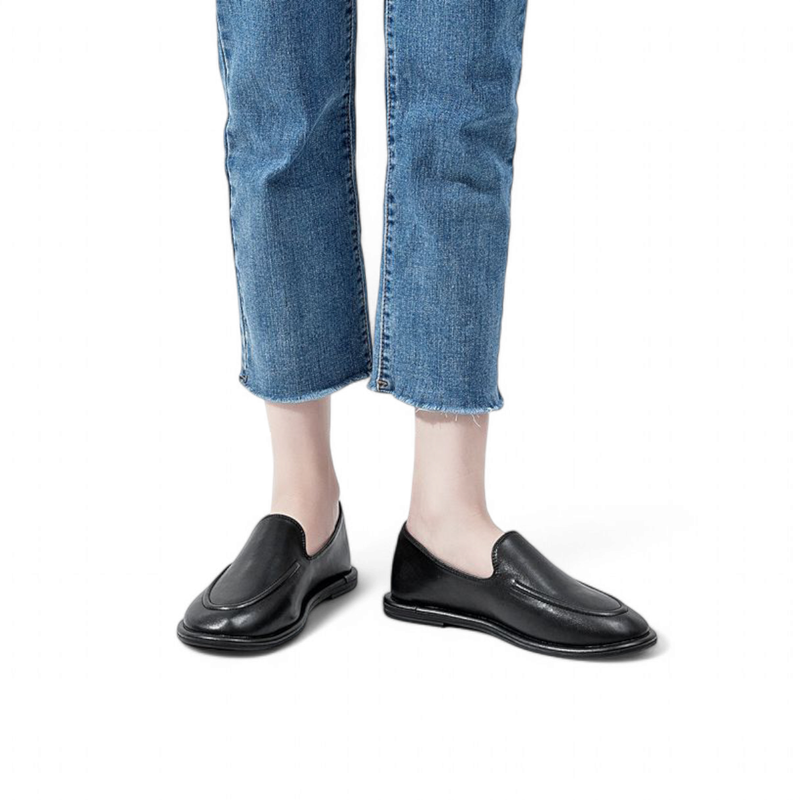 Black round‑toe leather loafers worn with jeans, side view