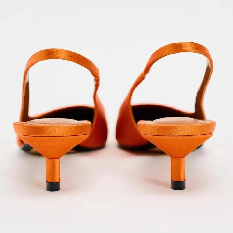 Rear angle showing slim kitten heels and slingback straps on white background