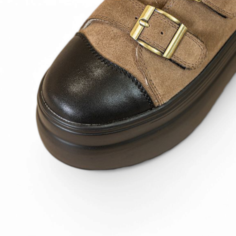 Close-up of black smooth cap toe, brown suede, twin brass-buckle straps, black platform.