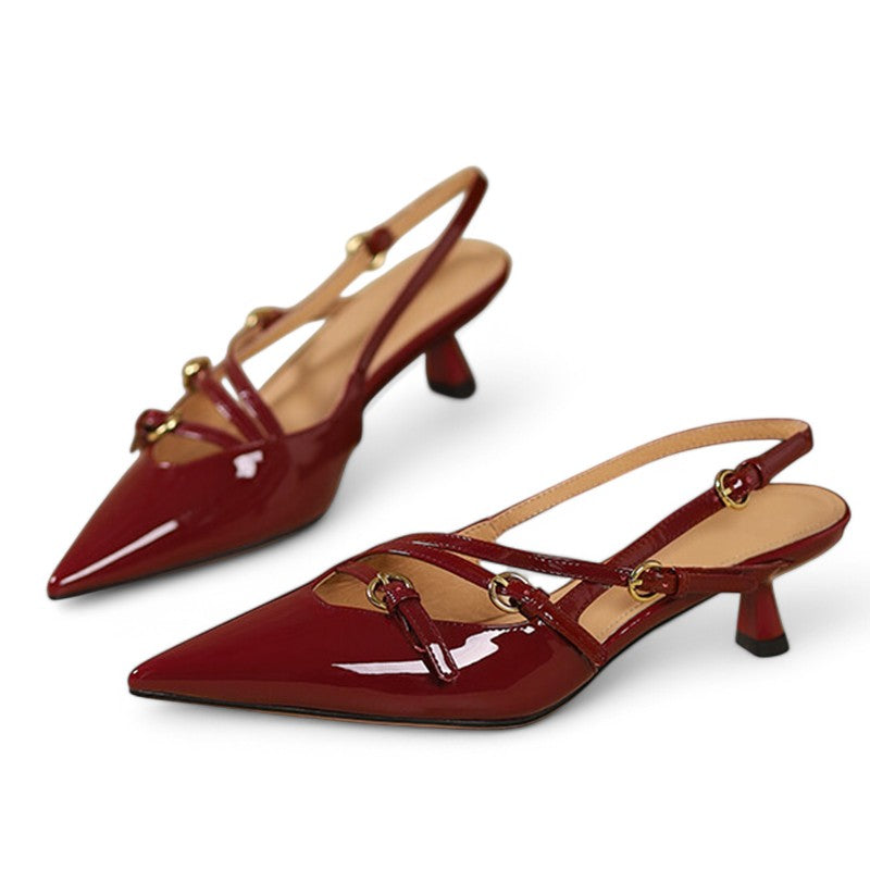 Studio shot of burgundy patent pumps side-by-side, kitten heels visible.