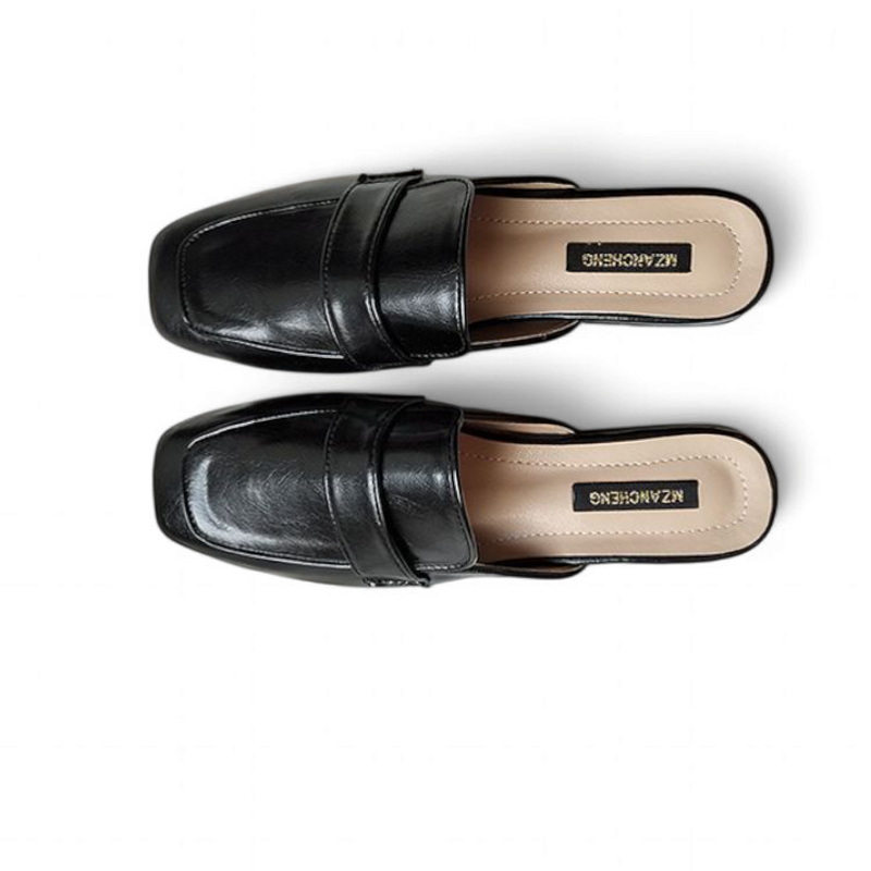 Flat‑lay of a parallel black mule pair viewed directly from above