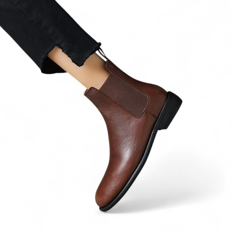 Merendy Salahyan Chelsea boots worn by a woman, showing a snug ankle fit, elegant brown leather finish, and comfortable low heel in a styled outfit.
