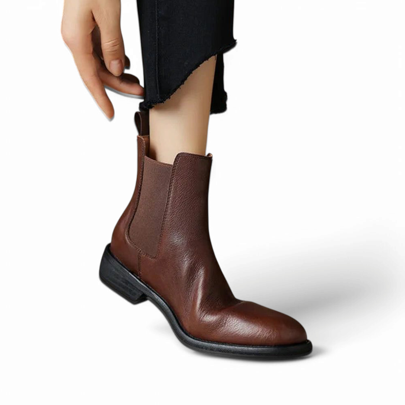 Merendy Salahyan Chelsea boots worn by a woman, showing a snug ankle fit, elegant brown leather finish, and comfortable low heel in a styled outfit.