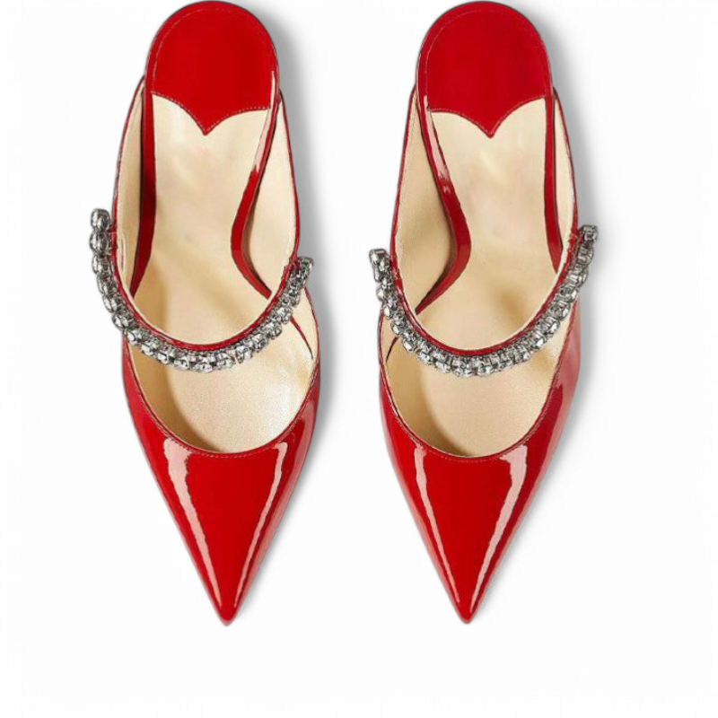 Top view of red patent mules showing pointed toes and crystal strap curve