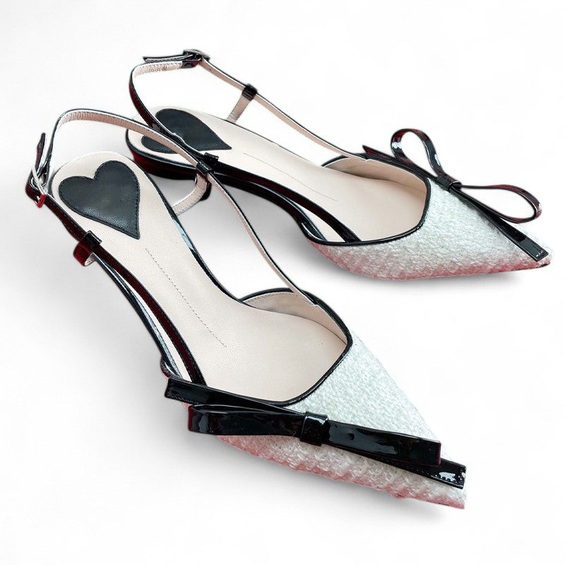  Merendy Shay shoes from the side: medium kitten heels, adjustable slingback strap, and a black bow on ivory leather.