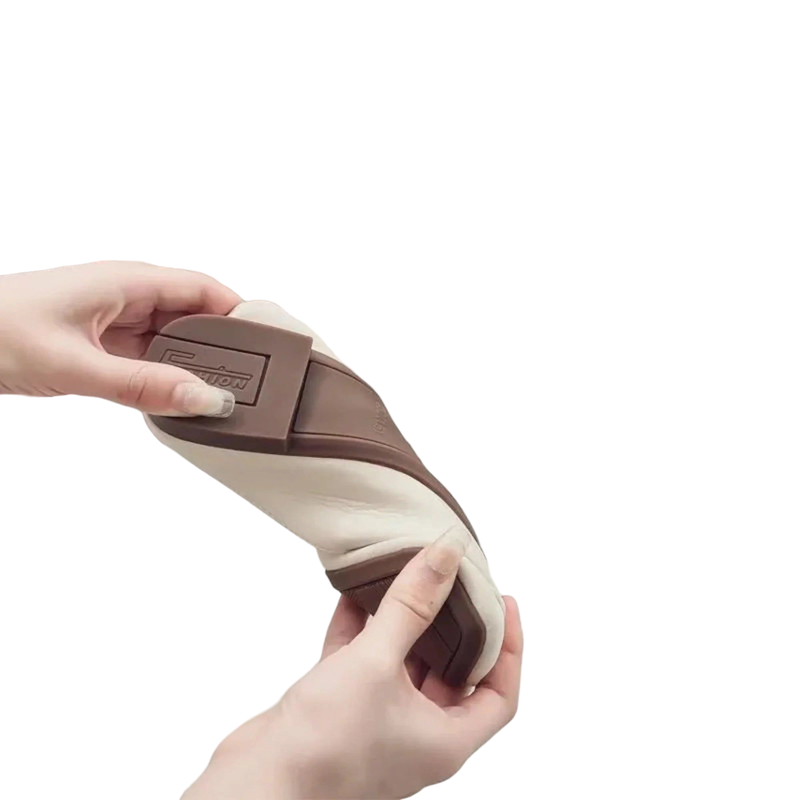 Close view showing the mule bent in hands to demonstrate flexible upper and cushioned interior.
