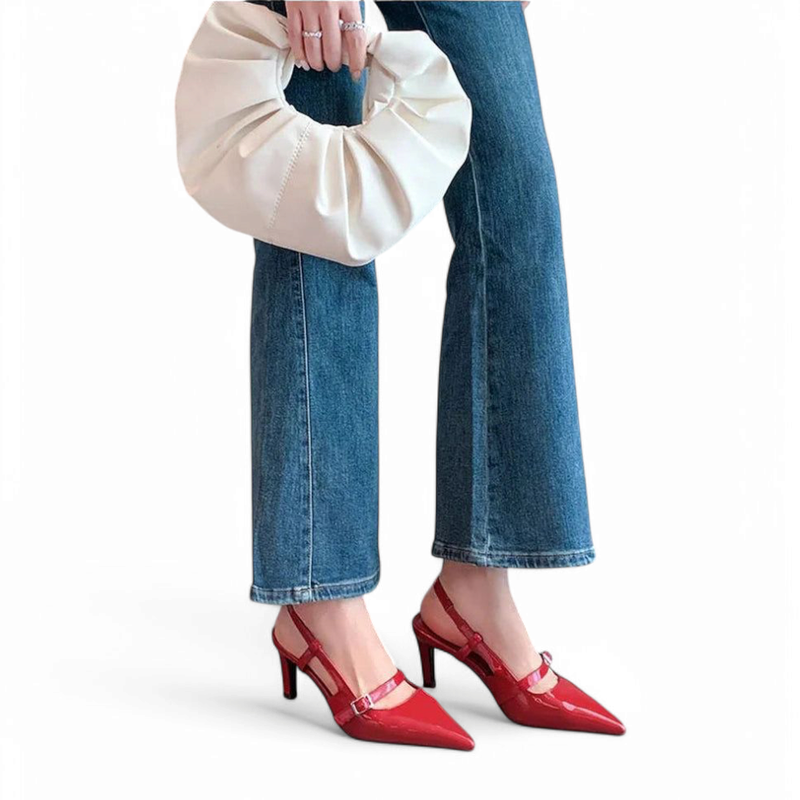 Red patent slingbacks styled with flared jeans and an ivory clutch.