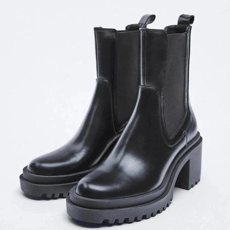 A pair of black boots shown from an angle, displaying both sides and the rounded front with a thick platform sole.