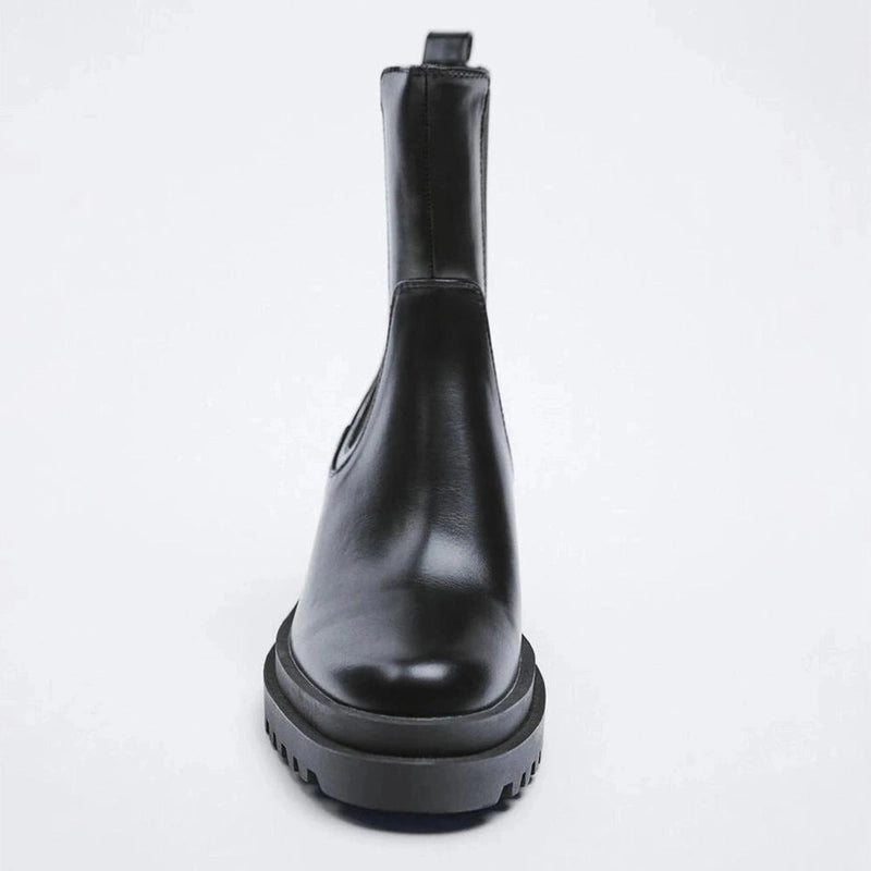 Single black boot shown from the front, focusing on the rounded toe and elevated sole.