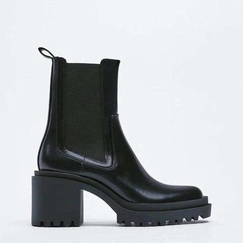 Black Chelsea boot in a full side view showing the elastic panel and high chunky heel.